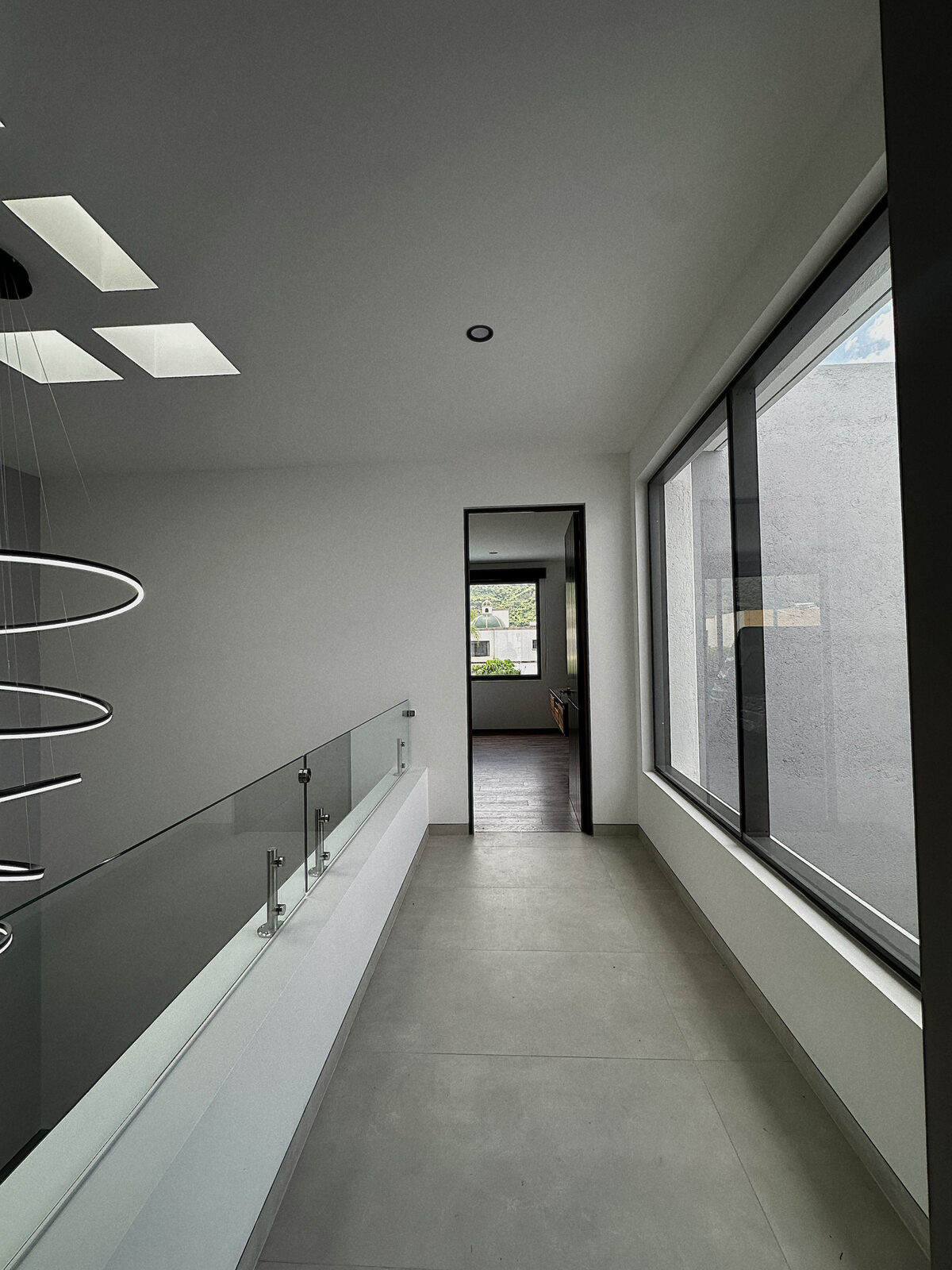 Upper floor hallway with glass railing · Casa Britania, contemporary home in Morelia