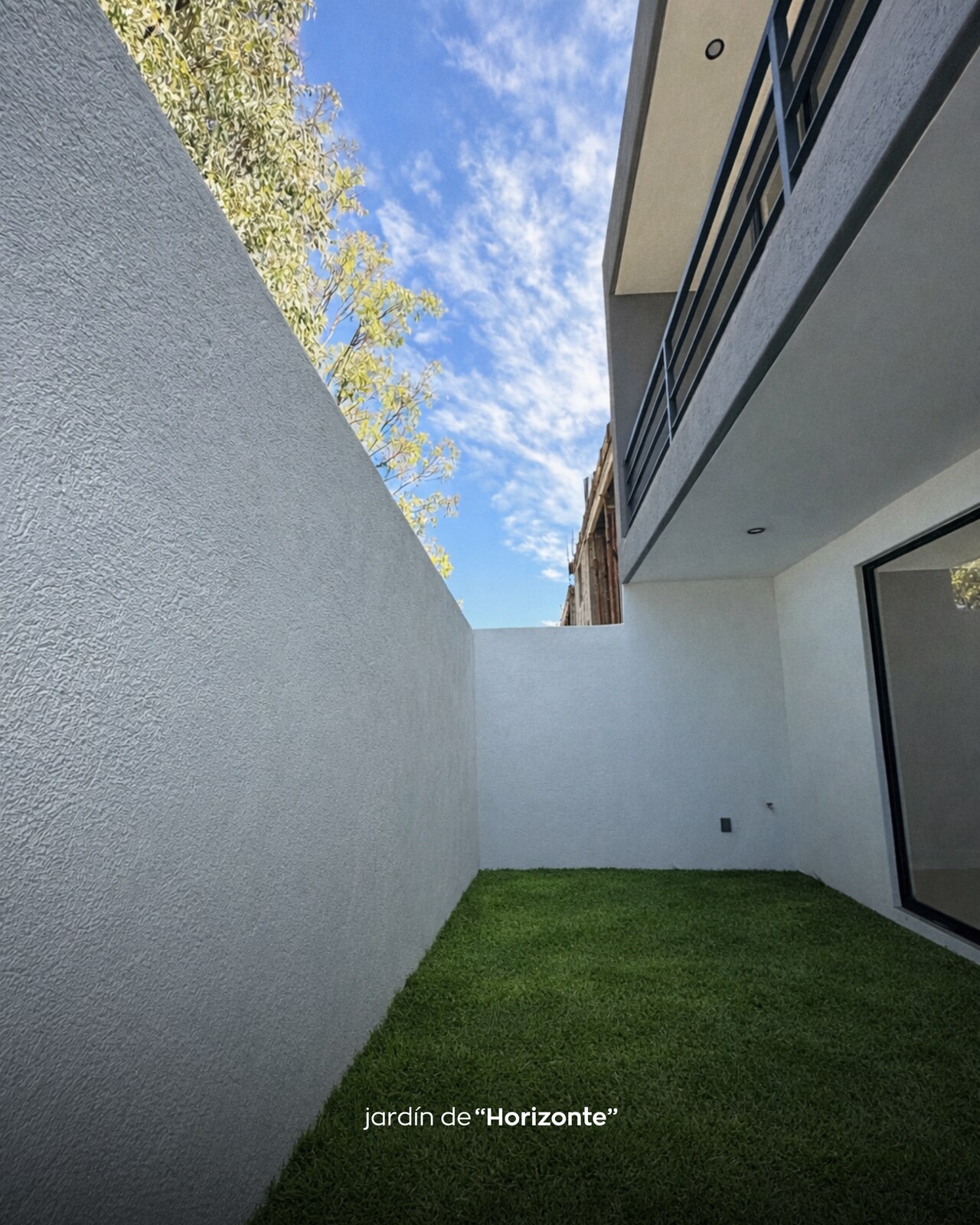 Jardín lateral con muros blancos y balcón superior · Casa Horizonte por Mircon en Morelia