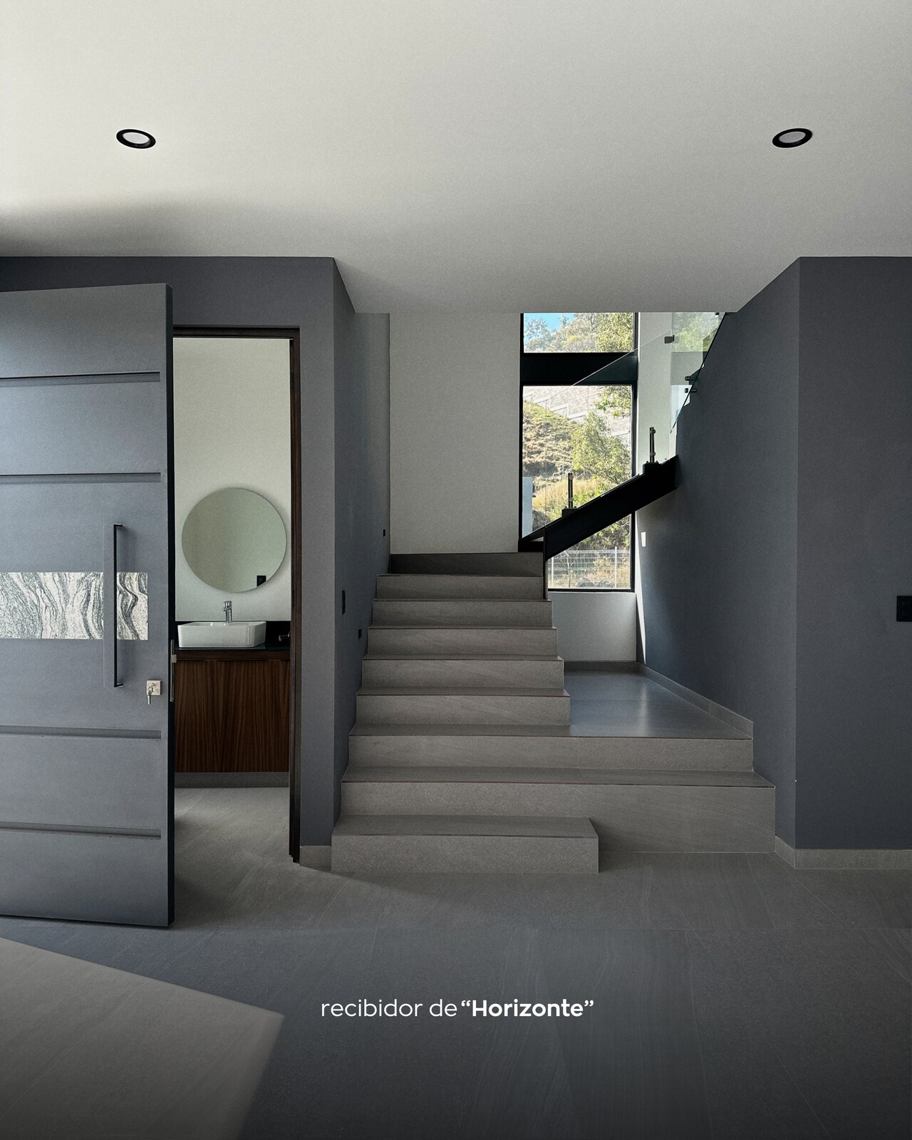Recibidor con escalera moderna y baño de visitas · Casa Horizonte por Mircon Constructora