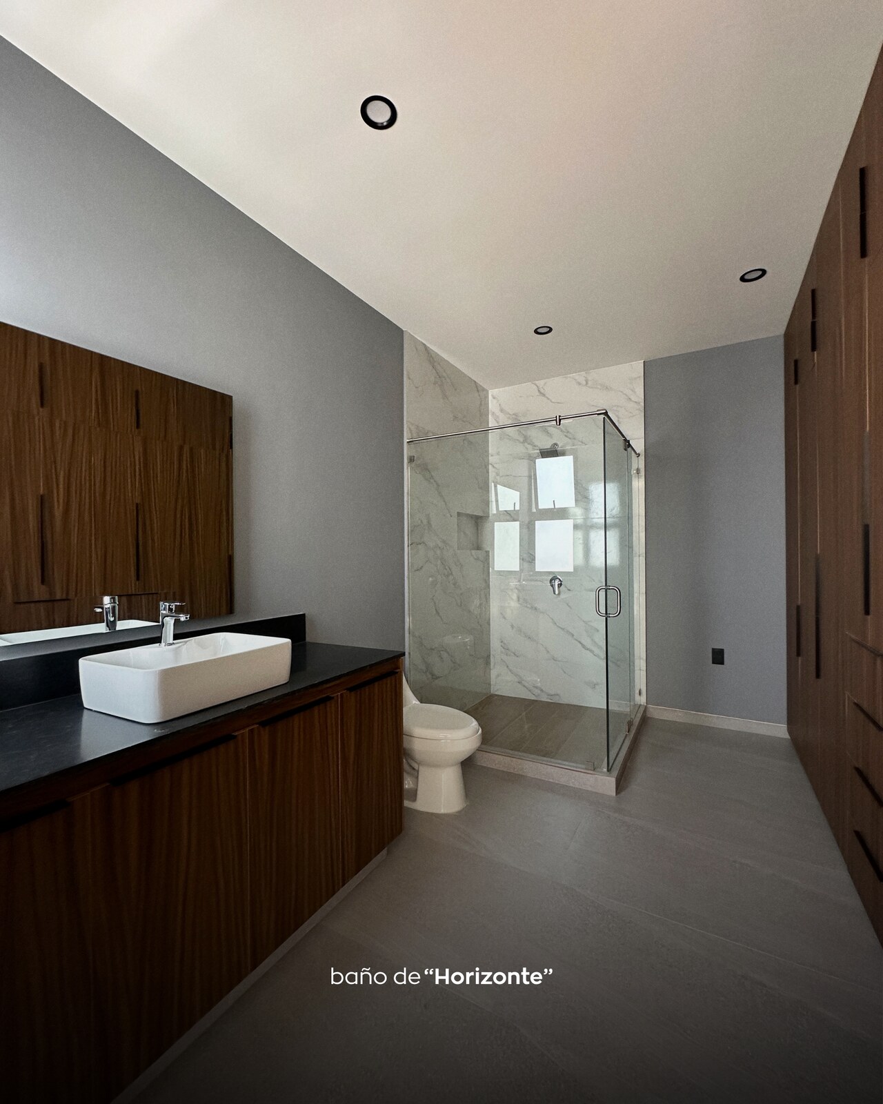 Baño principal con regadera de mármol blanco y mueble de madera · Casa Horizonte por Mircon