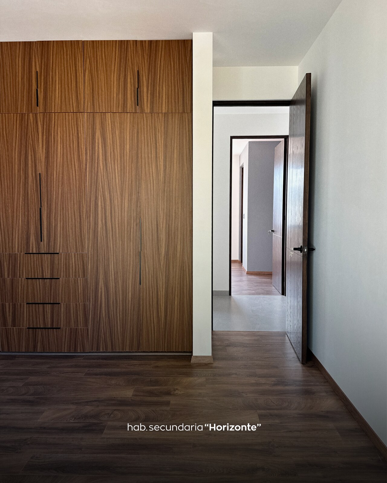 Habitación secundaria con closet de madera y acceso a otra recámara · Casa Horizonte