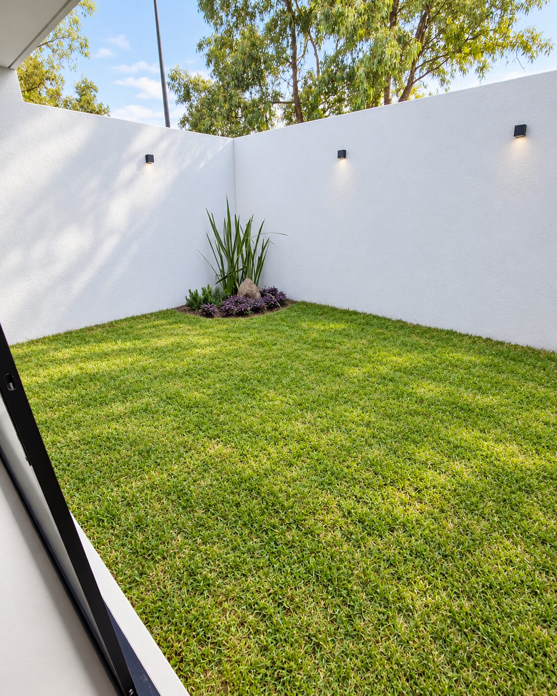 Backyard with natural lawn and white walls · Casa Magna, Mircon Constructora in Morelia