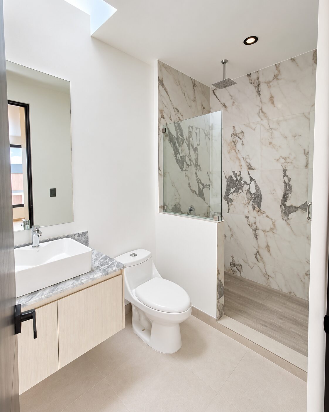 Full bathroom with marble shower and glass panel · Casa Magna, Mircon Constructora