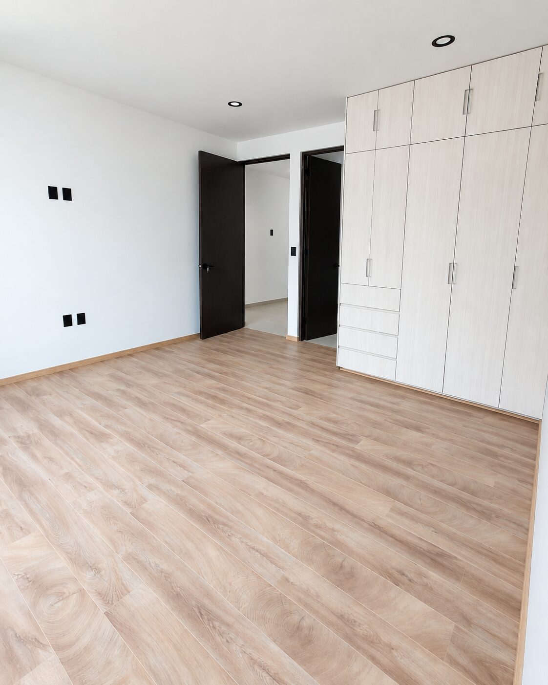 Master bedroom with wood closet and wood-look floor · Casa Magna, builder in Morelia